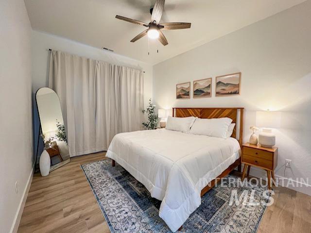 bedroom with baseboards, light wood-type flooring, and ceiling fan