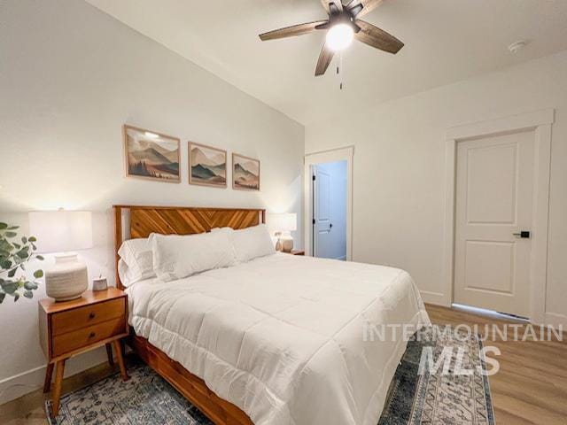 bedroom with baseboards, ceiling fan, and wood finished floors