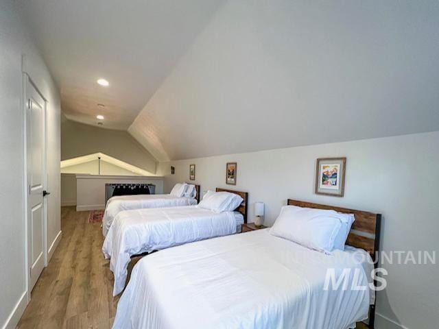 bedroom with recessed lighting, baseboards, lofted ceiling, and wood finished floors