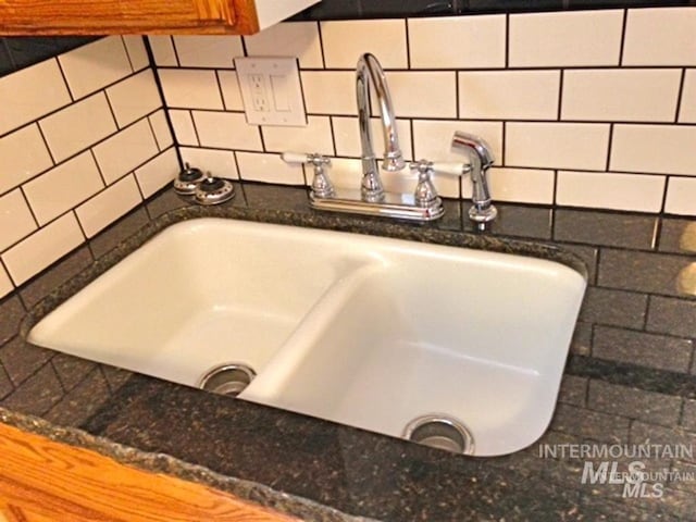 interior details featuring dark stone countertops, tasteful backsplash, and a sink