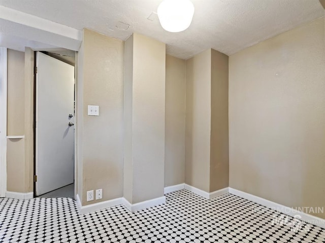empty room featuring baseboards and a textured ceiling