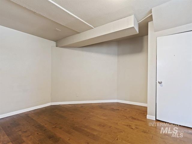 finished basement featuring baseboards and wood-type flooring