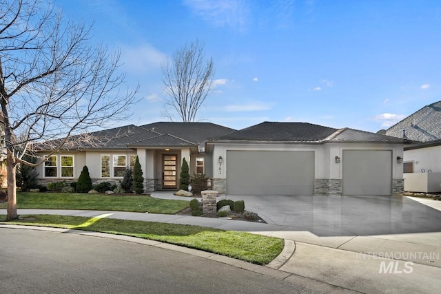 prairie-style house featuring a garage, stone siding, a front yard, and stucco siding