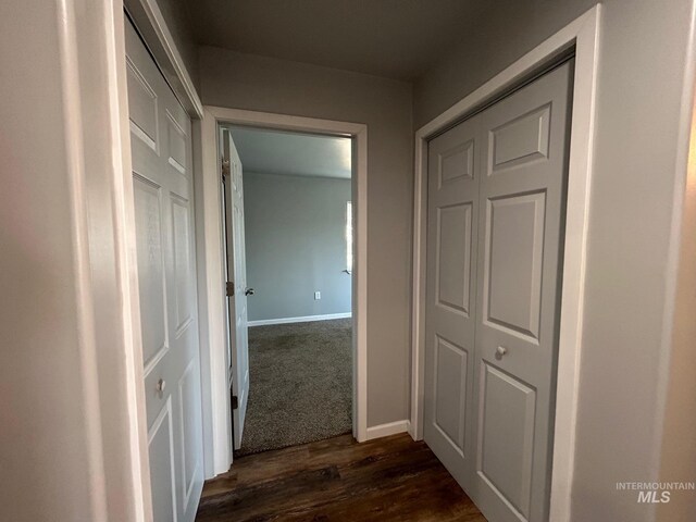 corridor with dark hardwood / wood-style flooring