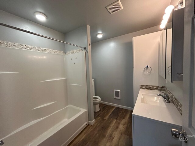 full bathroom with hardwood / wood-style floors,  shower combination, toilet, and vanity