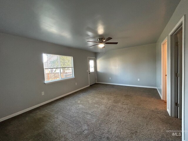 unfurnished room featuring ceiling fan and dark colored carpet