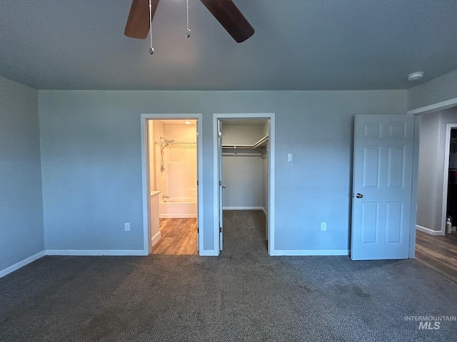 unfurnished bedroom featuring a walk in closet, carpet flooring, ceiling fan, and a closet