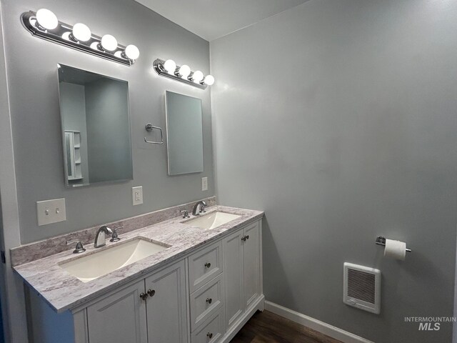 bathroom featuring double sink vanity and wood-type flooring