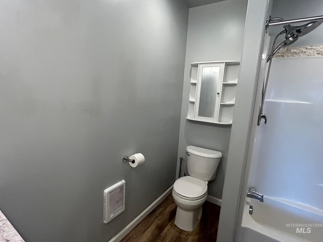 bathroom featuring toilet, hardwood / wood-style flooring, and bathtub / shower combination