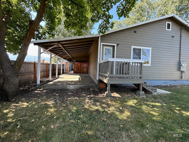 back of property featuring a lawn and a carport