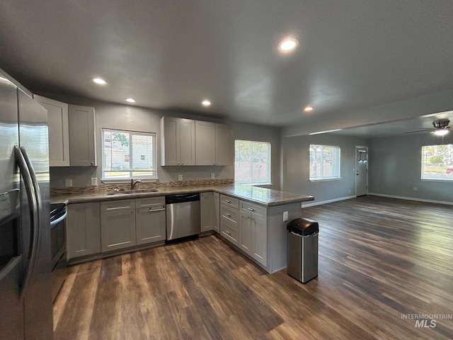 kitchen with ceiling fan, dark hardwood / wood-style floors, gray cabinets, appliances with stainless steel finishes, and kitchen peninsula