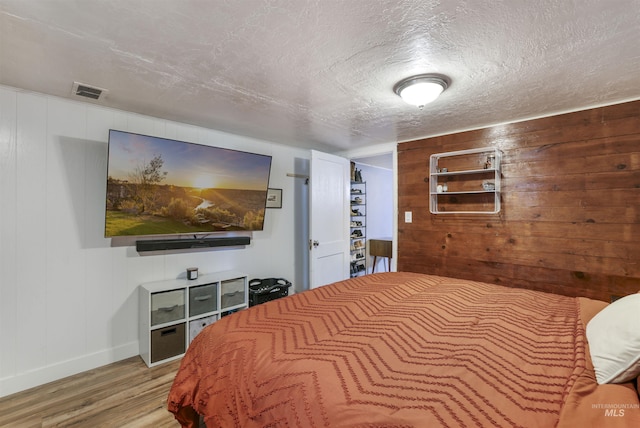 168 W Heyburn Ave, Twin Falls, ID 83301 - bedroom with wood finished floors, wooden walls, and a textured ceiling