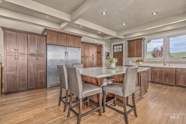 dining area with light wood-style flooring, recessed lighting, beam ceiling, and coffered ceiling
