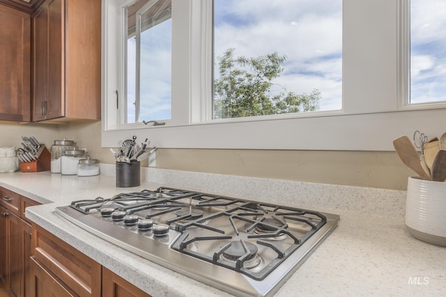 kitchen featuring stainless steel gas stovetop, light countertops, and brown cabinets