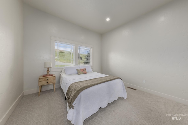 bedroom with light carpet and baseboards