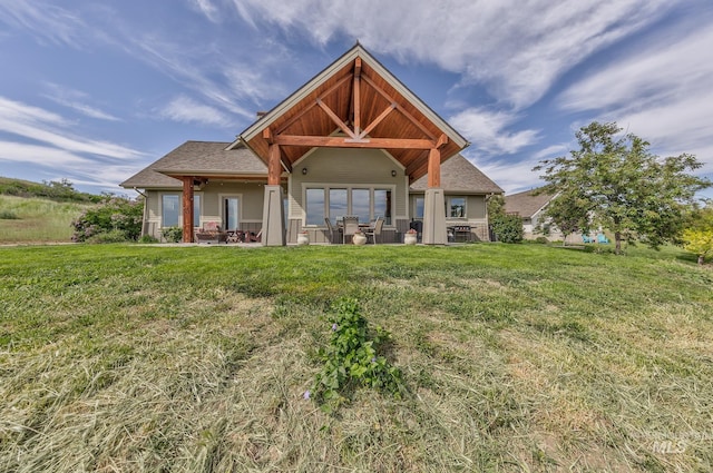 rear view of property with a yard and a patio area
