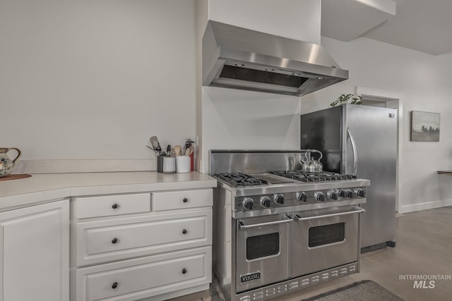 kitchen featuring stainless steel appliances, wall chimney exhaust hood, white cabinets, and light countertops