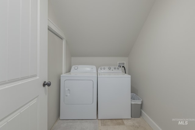 washroom featuring washing machine and dryer and baseboards