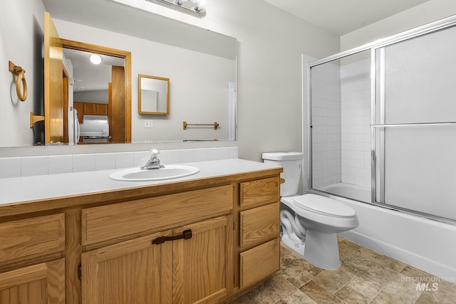 bathroom with shower / bath combination with glass door, toilet, and vanity