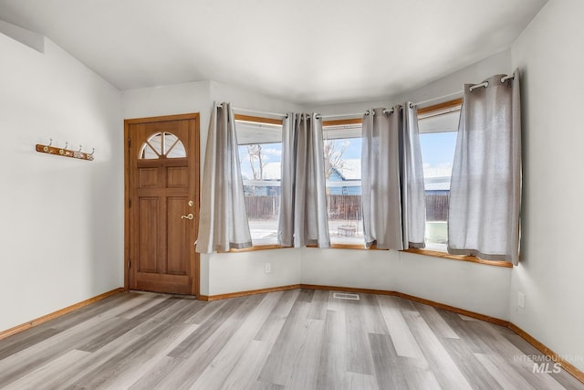 foyer featuring baseboards, visible vents, and light wood-type flooring