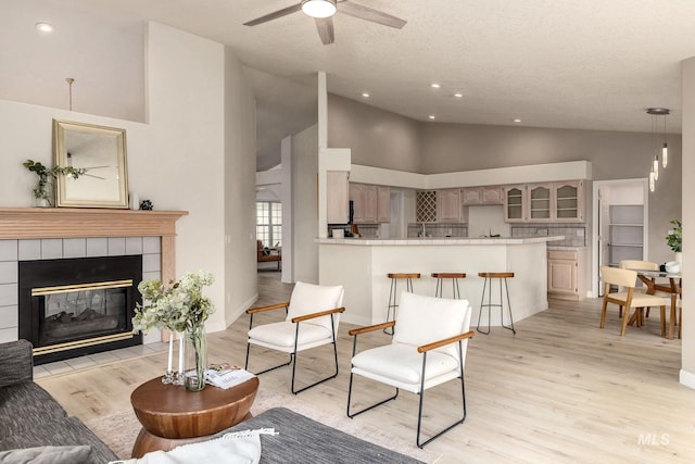 4335 W Quail Ridge Dr, Boise, ID 83703 - living room featuring high vaulted ceiling, light wood-type flooring, ceiling fan, a fireplace, and recessed lighting