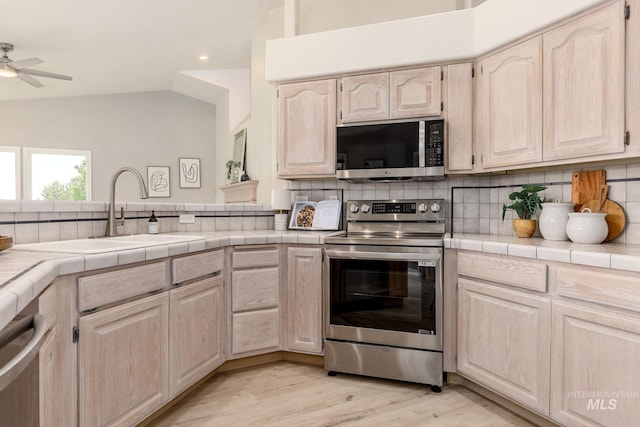 4335 W Quail Ridge Dr, Boise, ID 83703 - kitchen with stainless steel appliances, a ceiling fan, lofted ceiling, tasteful backsplash, and light brown cabinetry