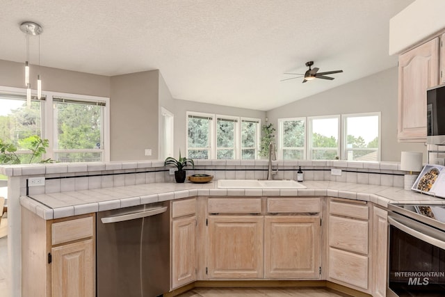 4335 W Quail Ridge Dr, Boise, ID 83703 - kitchen with stainless steel appliances, light brown cabinets, ceiling fan, vaulted ceiling, and light countertops