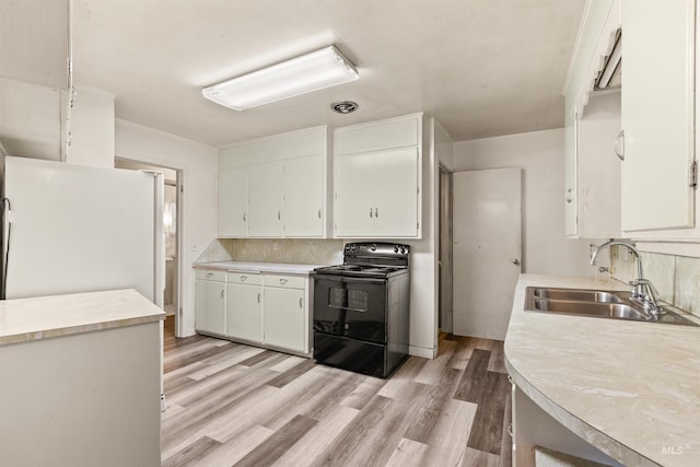 kitchen featuring white cabinetry, black electric range, light wood-type flooring, and sink