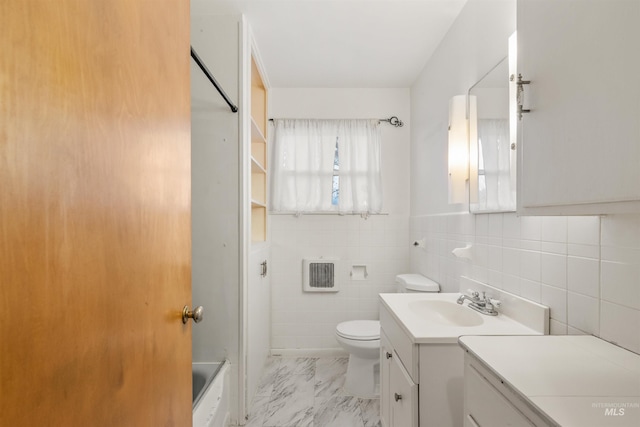 bathroom with vanity, toilet, tile walls, and a tub