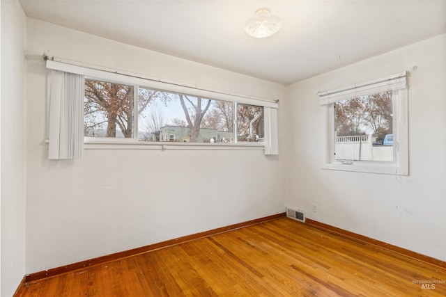 unfurnished room with hardwood / wood-style floors and plenty of natural light