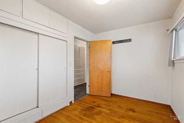 unfurnished bedroom featuring a closet and hardwood / wood-style floors