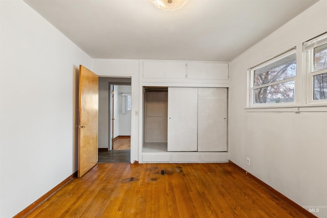 unfurnished bedroom with a closet and hardwood / wood-style floors