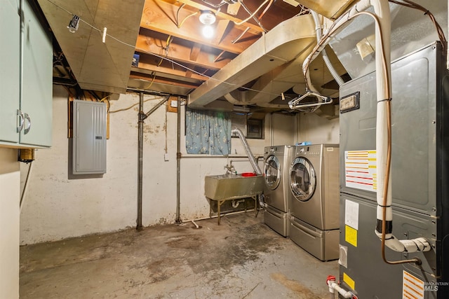 basement with electric panel, sink, washer and dryer, and heating unit