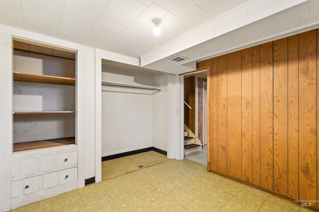 unfurnished bedroom featuring wooden walls