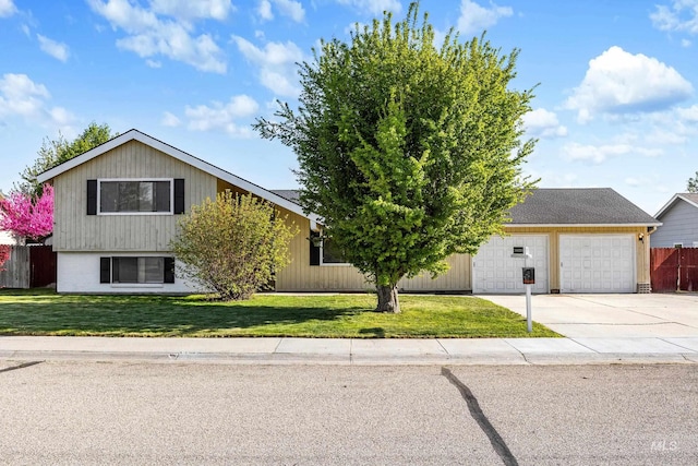 view of front of house with concrete driveway, fence, a front yard, and a garage