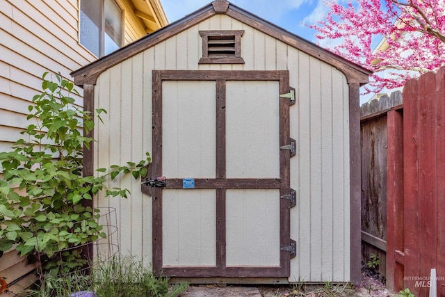 view of shed featuring fence