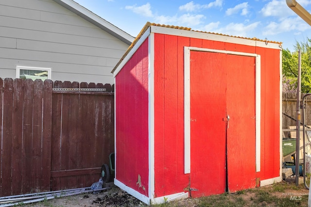 view of shed featuring fence