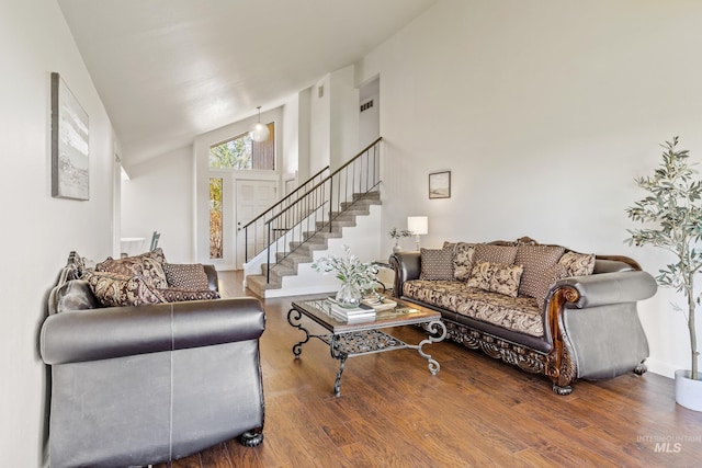 living room featuring baseboards, high vaulted ceiling, wood finished floors, and stairway