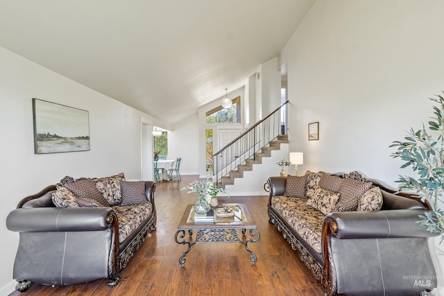living area with baseboards, high vaulted ceiling, wood finished floors, and stairway