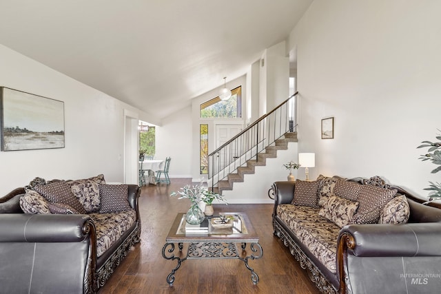 living room with baseboards, high vaulted ceiling, wood finished floors, and stairway