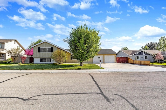 view of front facade with fence, concrete driveway, a front lawn, and a residential view