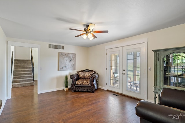 living area featuring ceiling fan, french doors, visible vents, dark wood-style floors, and stairs