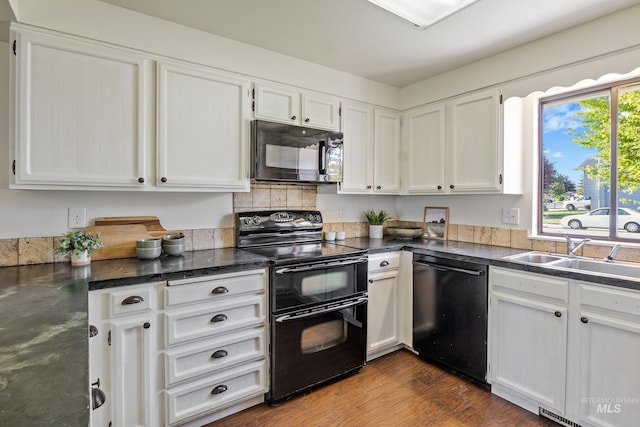 kitchen with white cabinetry, dark wood-style floors, a sink, and black appliances