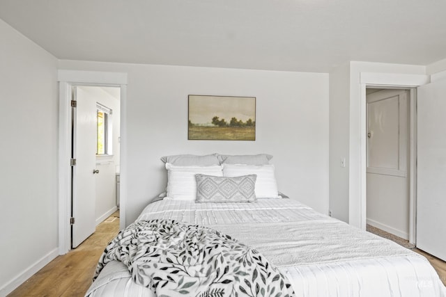 bedroom with baseboards and light wood finished floors