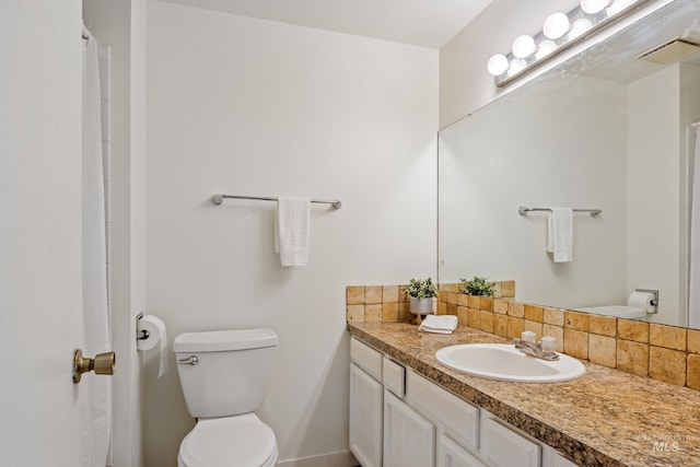 bathroom with vanity, backsplash, and toilet
