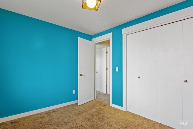 unfurnished bedroom featuring a closet, carpet, and baseboards