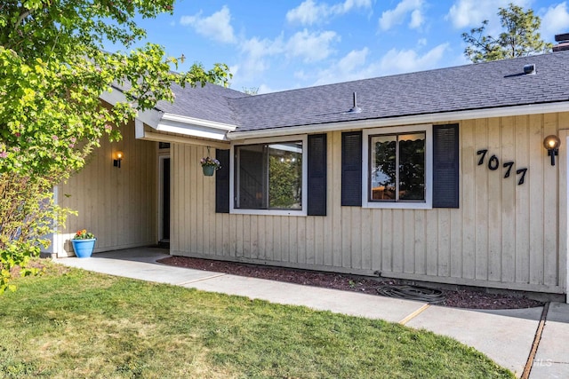view of front of house with a shingled roof and a front yard
