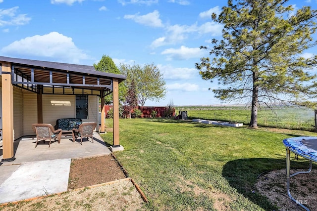 view of yard with fence, a patio area, a trampoline, and an outdoor hangout area