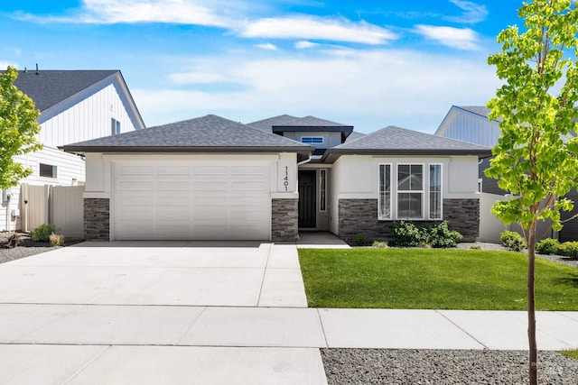 prairie-style house featuring stone siding, a garage, concrete driveway, and stucco siding
