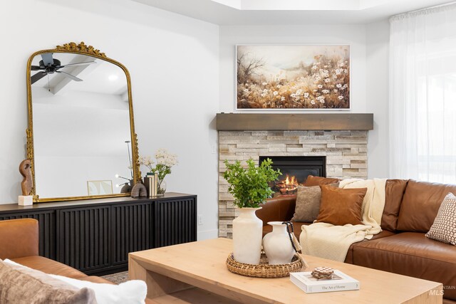 living room featuring ceiling fan and a fireplace